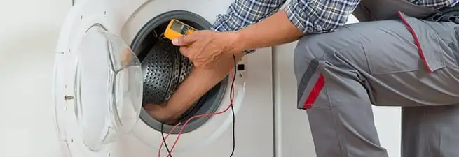 Dryer repair technician inspecting and repairing a clothes dryer in Irvine, CA