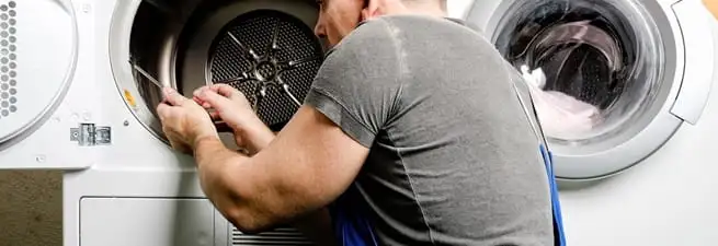 Dryer repair technician fixing a clothes dryer drum in Irvine, CA