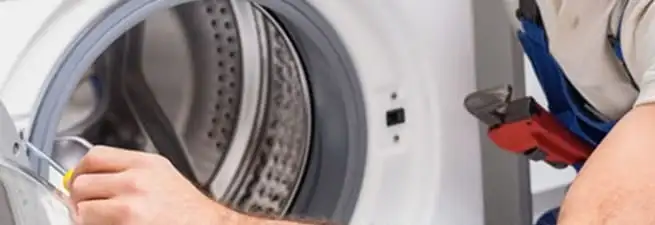 Appliance technician repairing a clothes dryer drum and internal parts in Irvine, CA