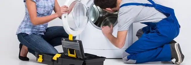 Washer repair technician inspecting a front-load washing machine with tools in Irvine, CA