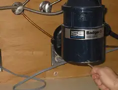 Garbage disposal repair technician tightening the mounting ring under a sink in Irvine, CA