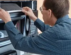 Appliance repair technician replacing a microwave vent filter in Irvine, CA