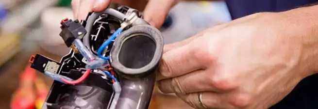 Vacuum repair technician reconnecting wiring and components in Irvine, CA