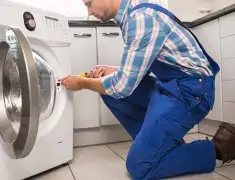Washing machine repair technician servicing a front-load washer in Irvine, CA