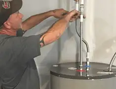 Water heater repair technician tightening supply line connections in Irvine, CA