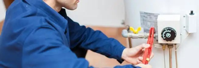 Water heater repair technician adjusting the temperature control and gas valve in Irvine, CA